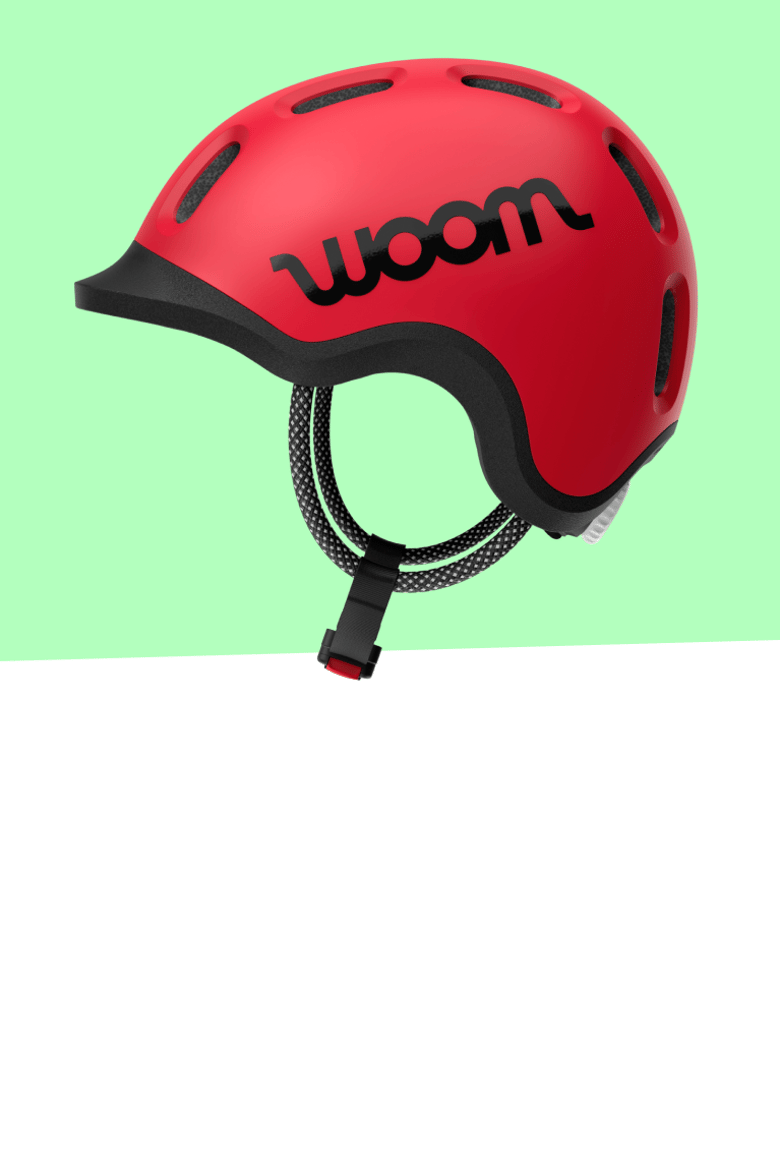 Red woom READY kids helmet in side view with black logo, visor and straps.