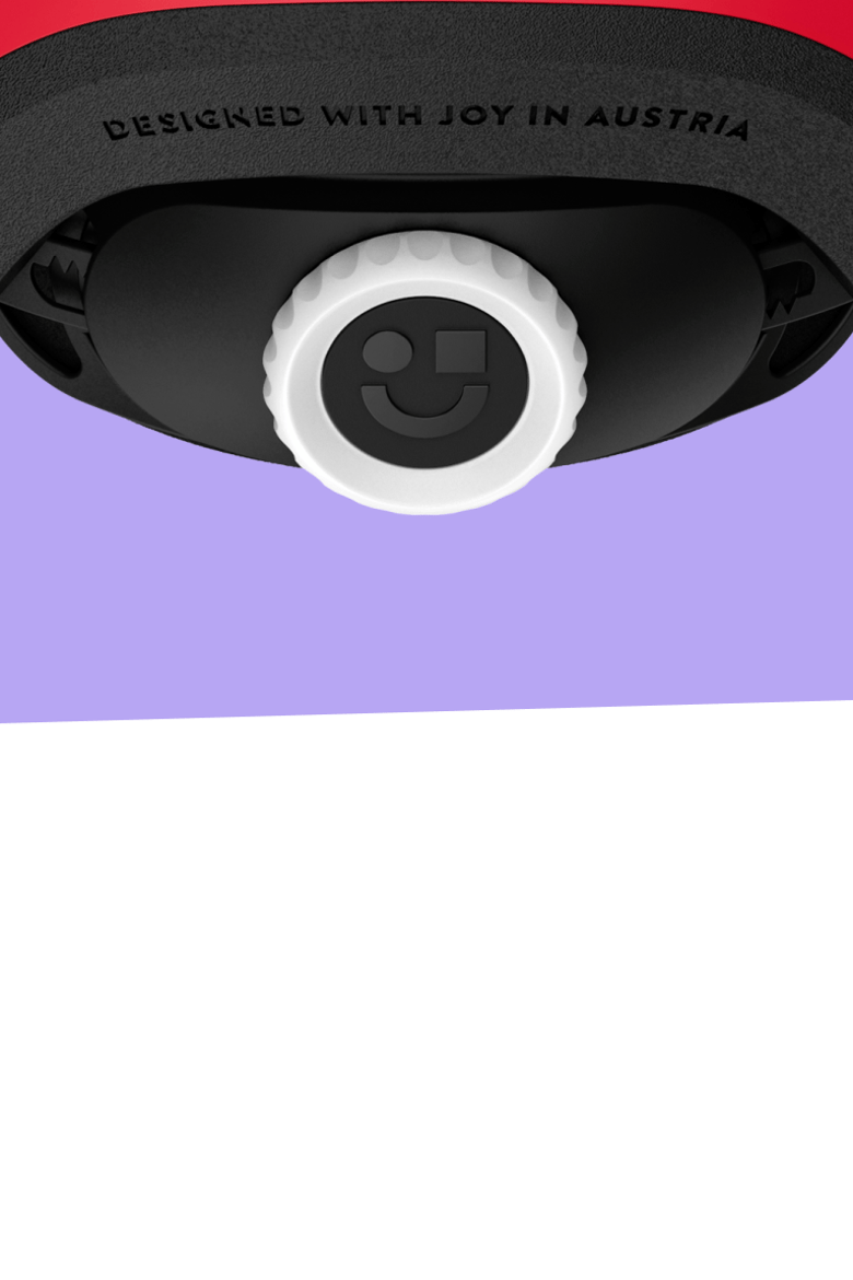 Close-up of the woom READY helmet dial with smiley symbol and text "DESIGNED WITH JOY IN AUSTRIA".