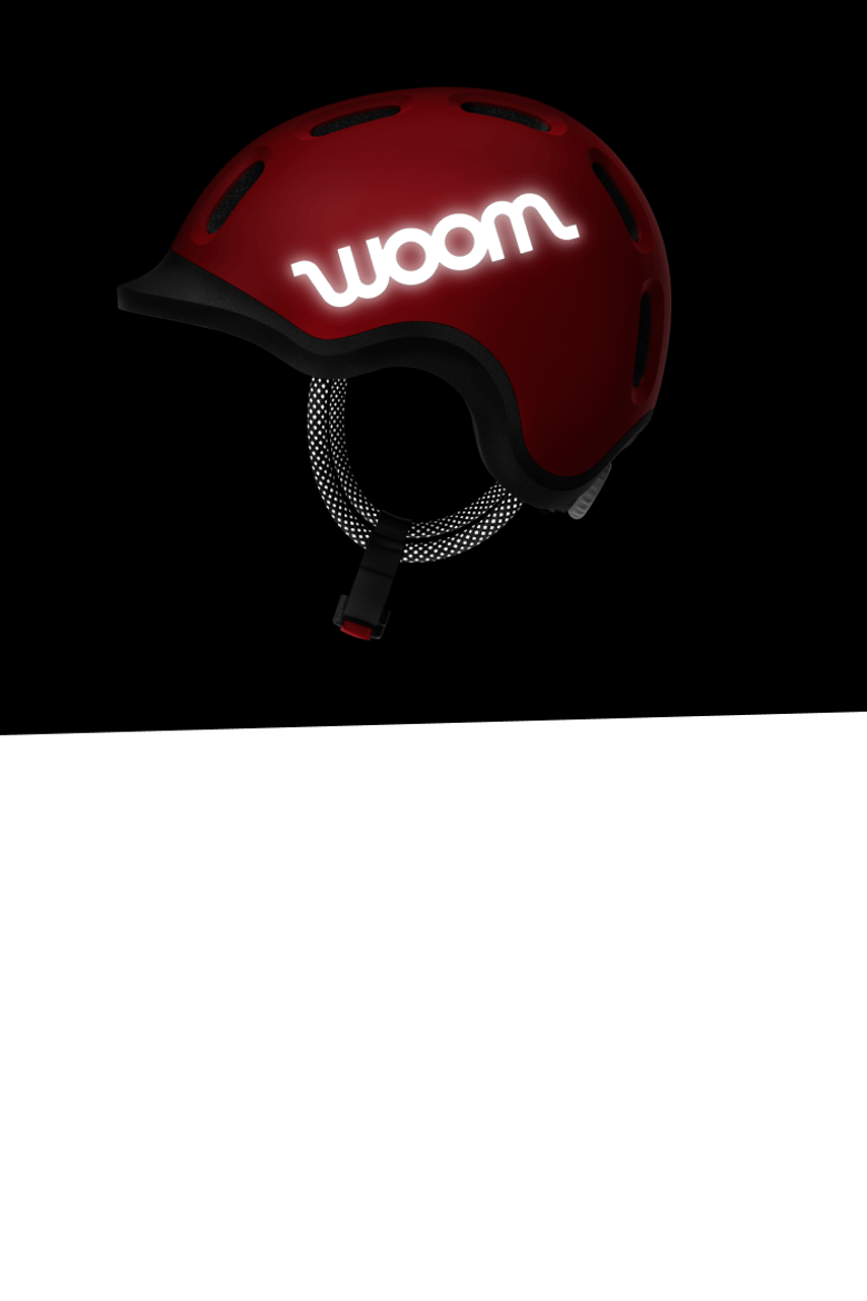 Red woom READY helmet in the dark with a highly reflective woom logo on the side.