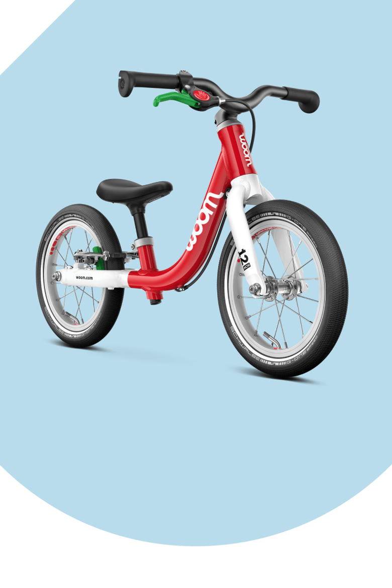 Red woom balance bike on a light blue background.