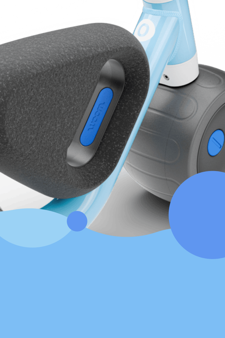 Detaljbild av sittytan på woom WOW. Balanscykelns logotyp, däck och ram syns också. På däcken syns texten ”enjoy the ride”.