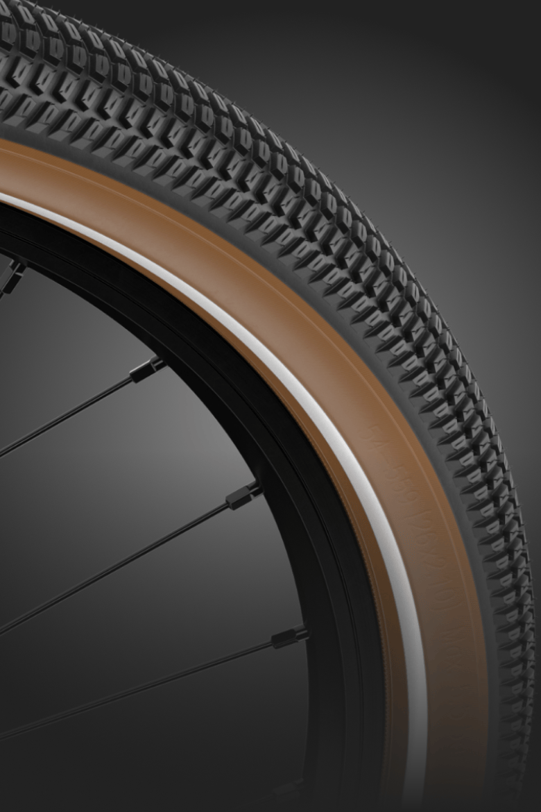 Detailansicht des Reifens am woom EXPLORE e – mit schwarzem Profil und braunen Reifenflanken.