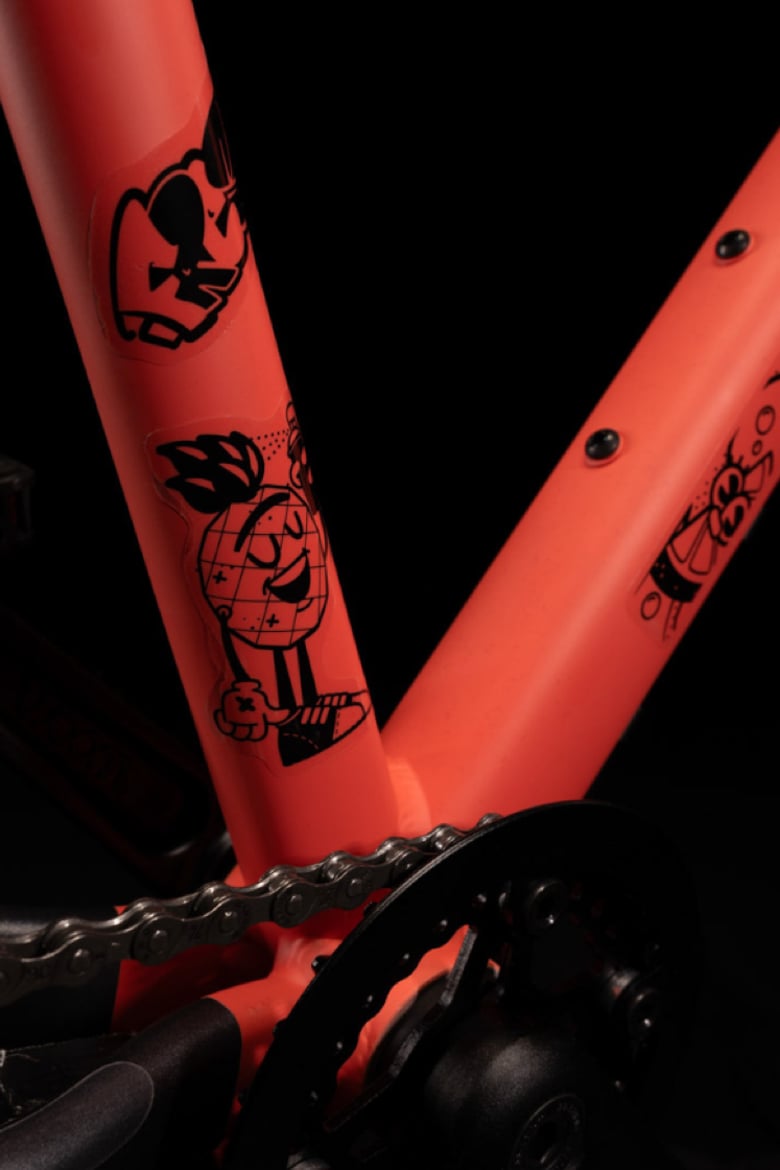 Gros plan sur un cadre de woom EXPLORE rouge recouvert d’autocollants noirs transparents.