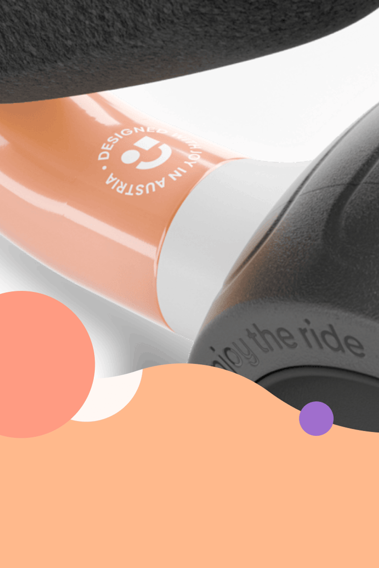 Detaljbild av ramen på balanscykeln woom WOW med den tryckta texten ”Designed with joy in Austria”