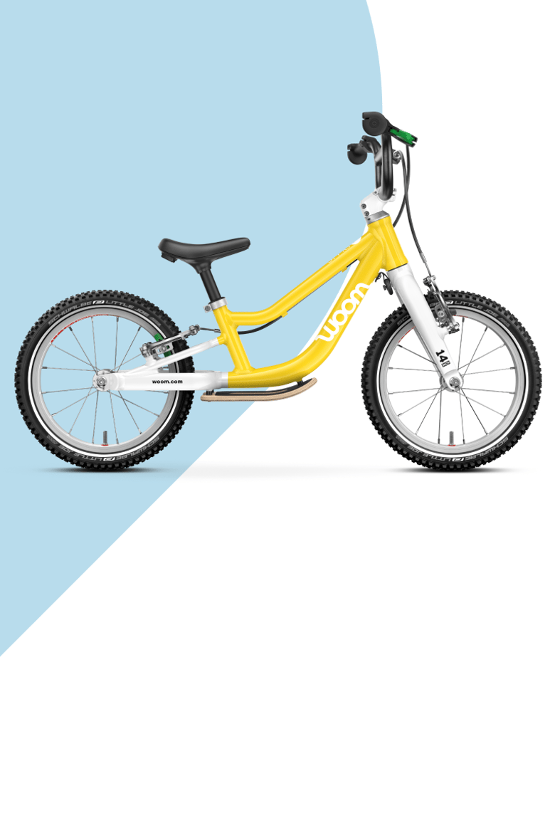 Yellow woom GO balance bike on a light blue and white background.