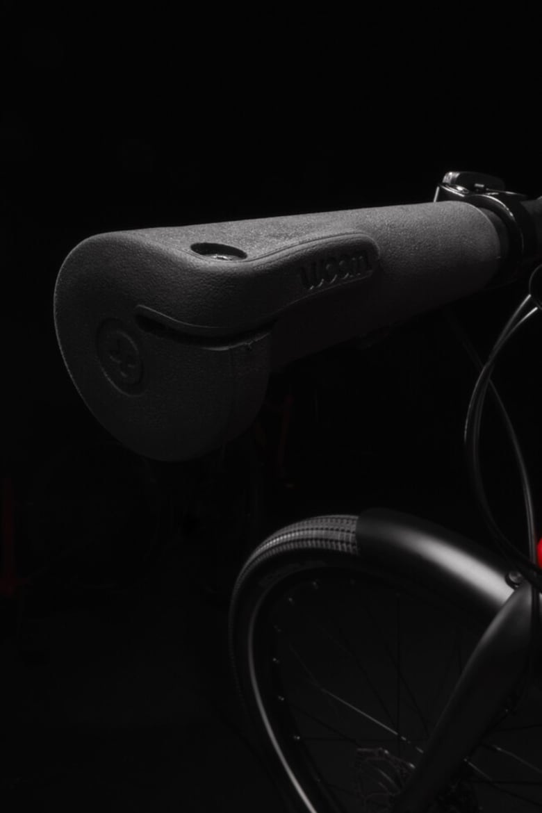 Gros plan de la poignée gauche du guidon au design ergonomique noir sur le vélo enfant woom EXPLORE.