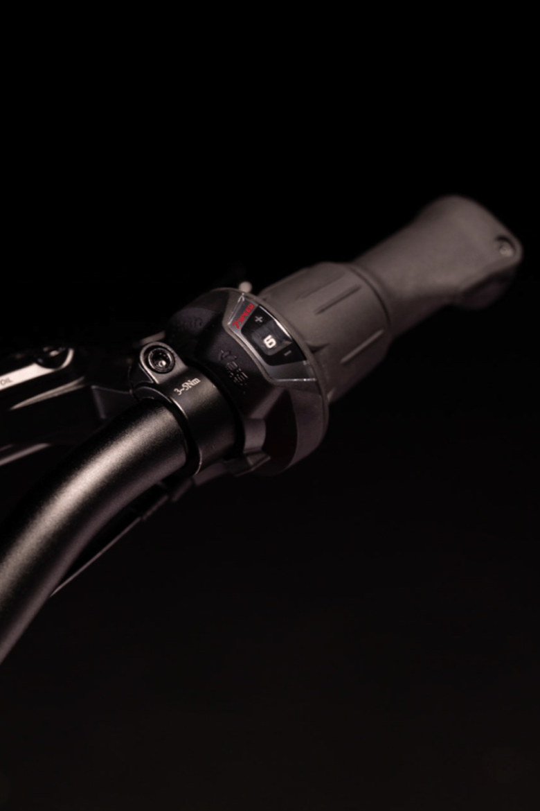 Guidon noir woom EXPLORE et poignée tournante Shimano noire avec indicateur de vitesse.