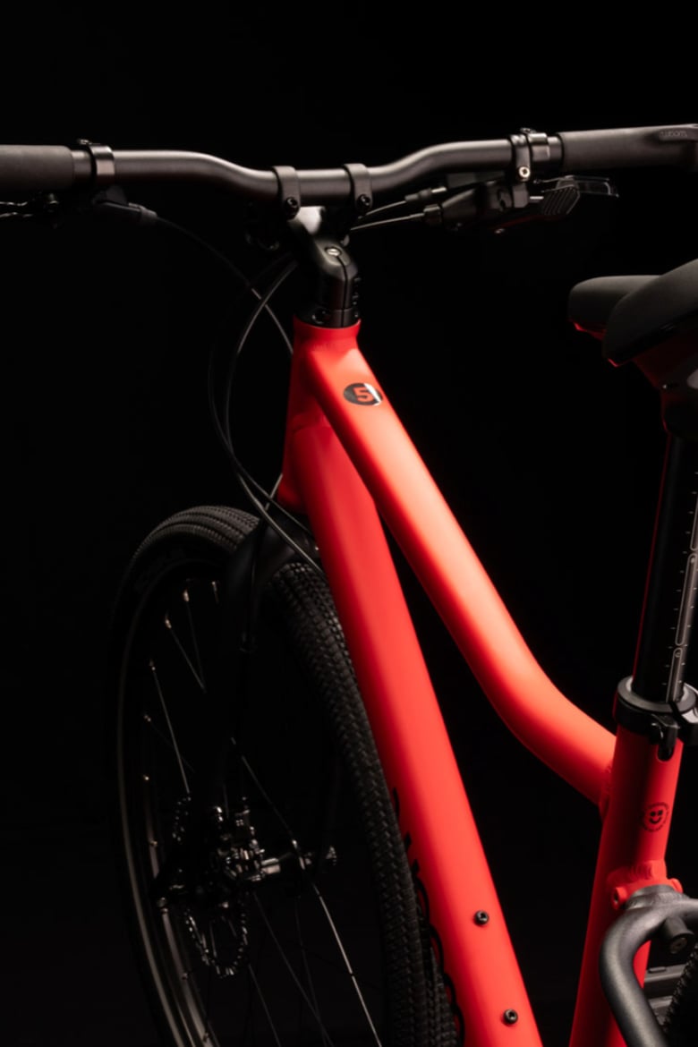 Red woom EXPLORE bicycle with black handlebars, black seatpost, black fork and black seatstays.