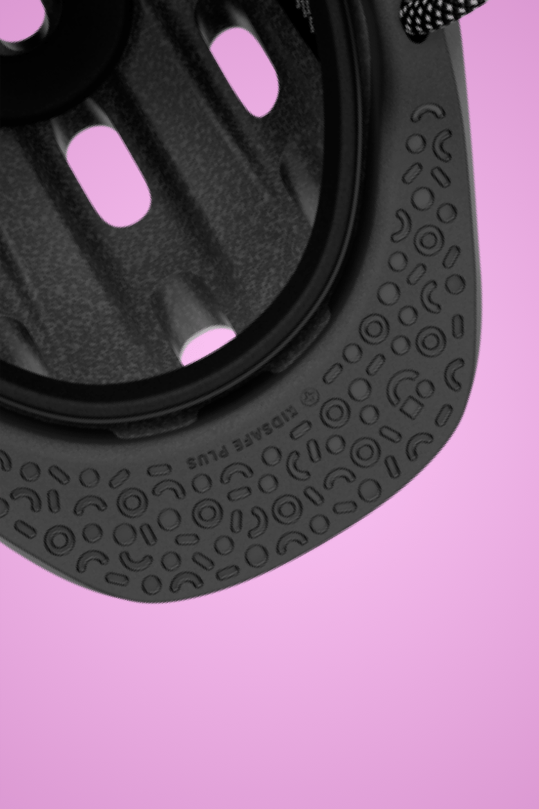Zoom sur les motifs de la visière noire amortissante du casque enfant READY, arrière-plan rose"