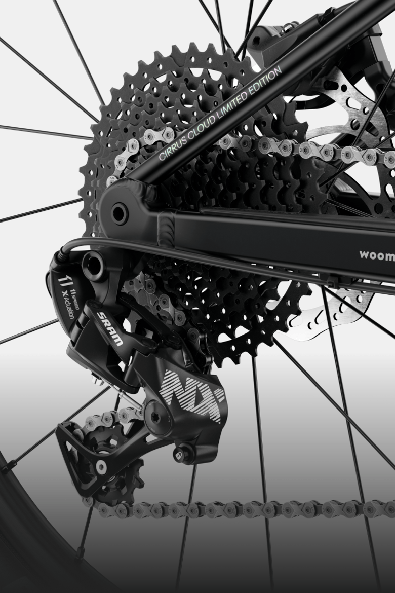 Detailed view of the SRAM drivetrain and chain on the rear wheel of the woom UP cirrus cloud.