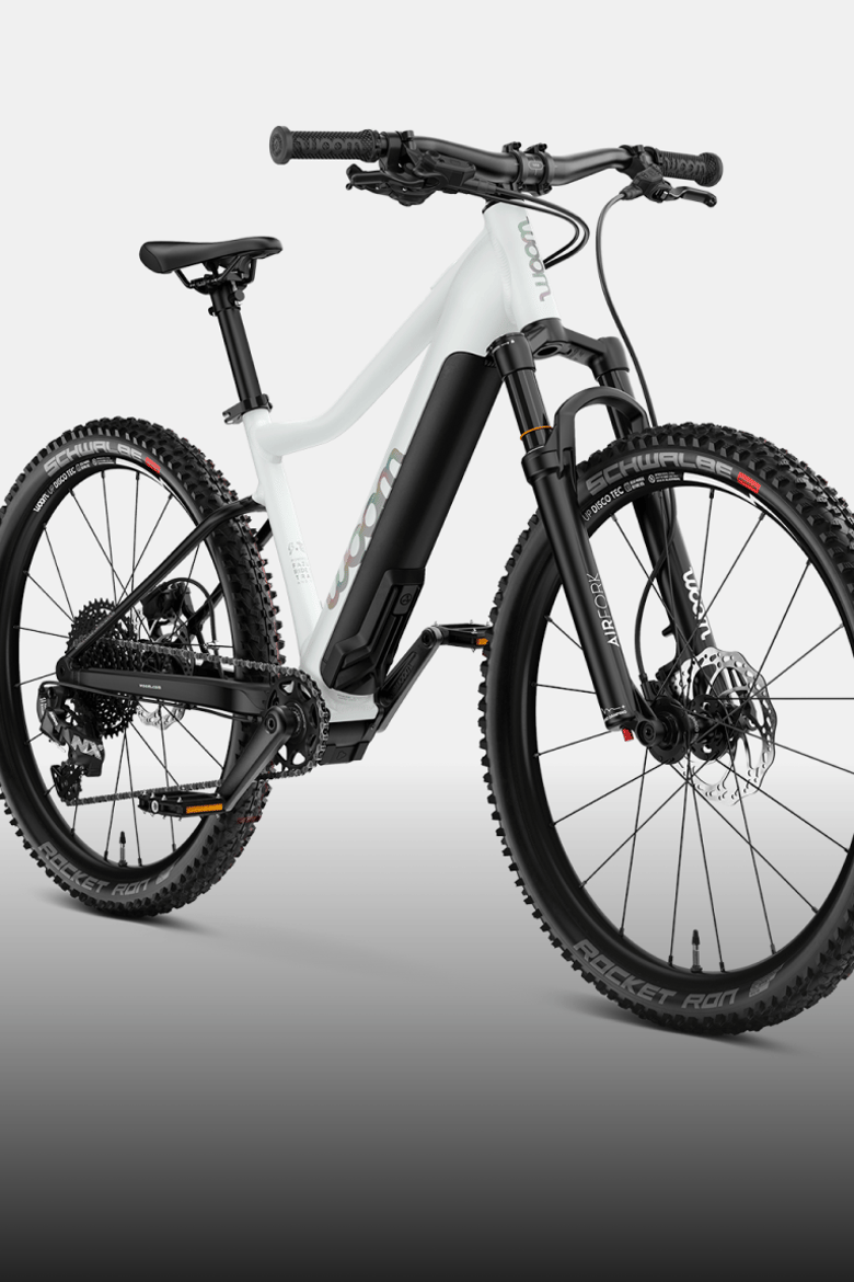 Angled view of the woom UP e-mountain bike in cirrus cloud against a black background.