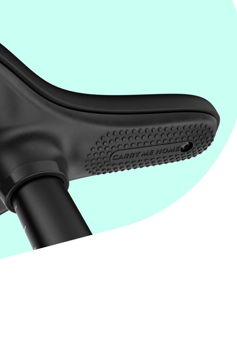 Zoom sur la face inférieure d’une selle woom noire avec l’inscription « Carry me home » sur la partie texturée.