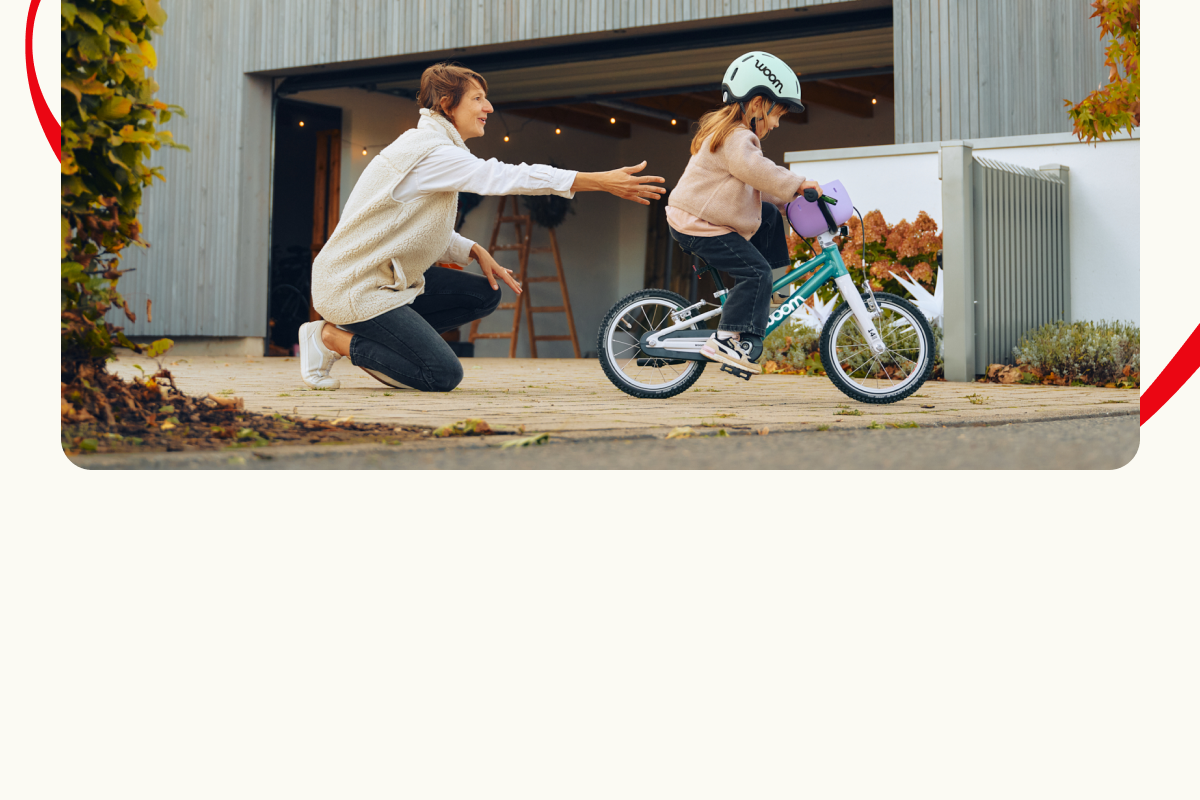 Un membre de la famille encourage une jeune fille qui découvre son nouveau vélo woom GO.
