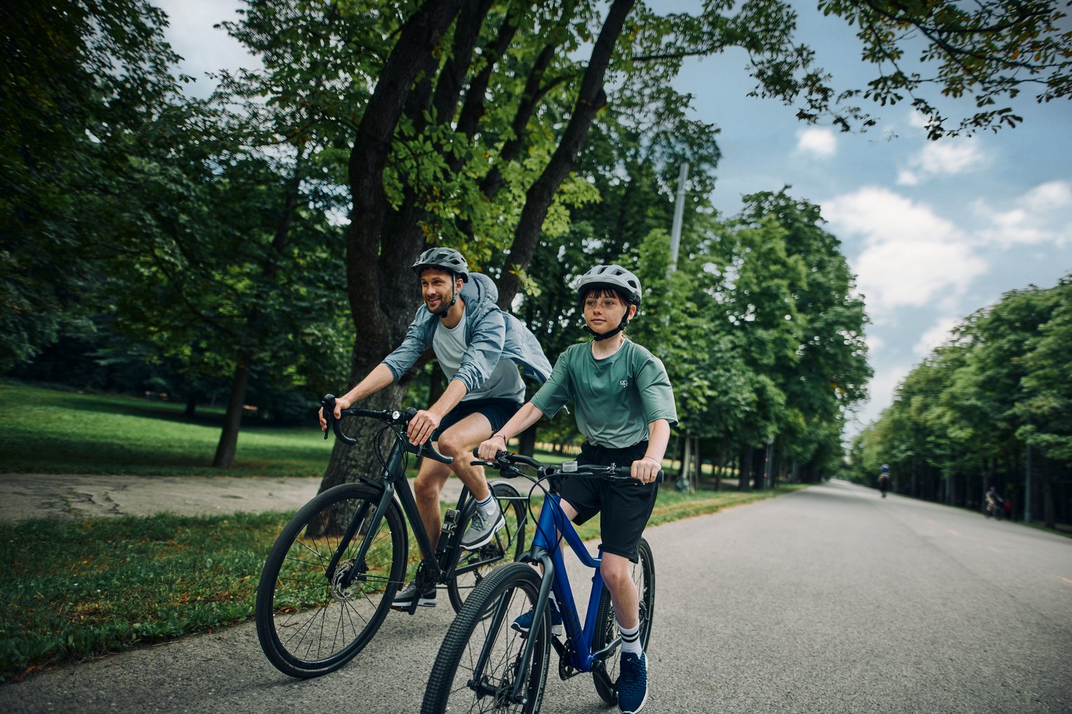 Father and son riding bikes, son riding a blue woom EXPLORE.