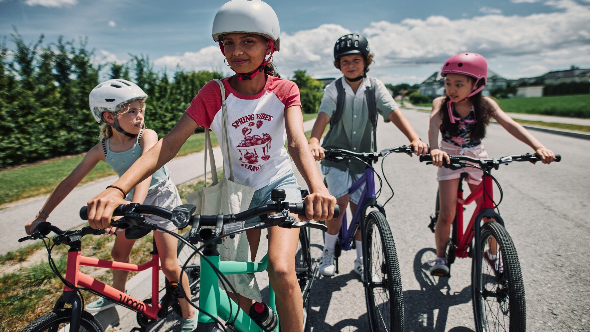 Fire børn og unge på cykler fra woom