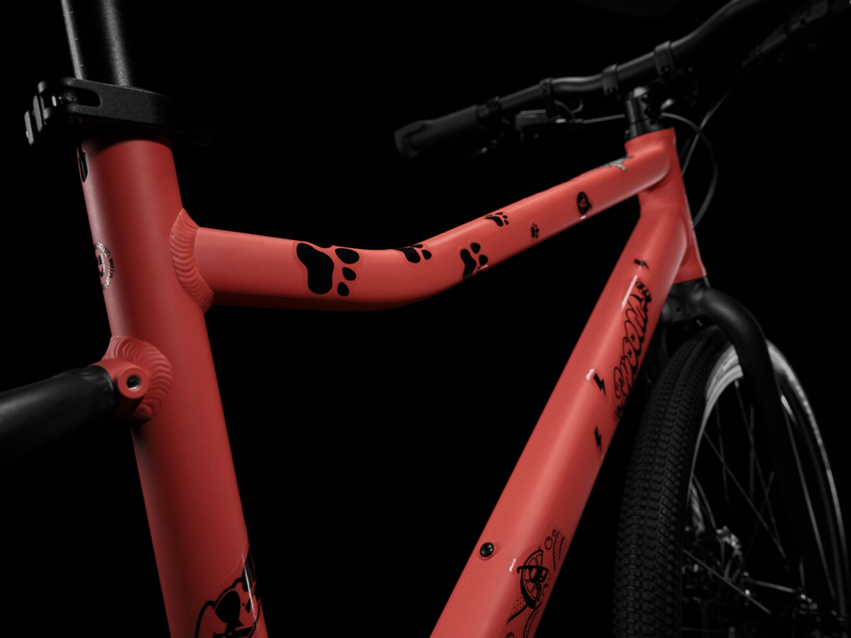 Gros plan sur un cadre de woom EXPLORE rouge recouvert d’autocollants noirs transparents.
