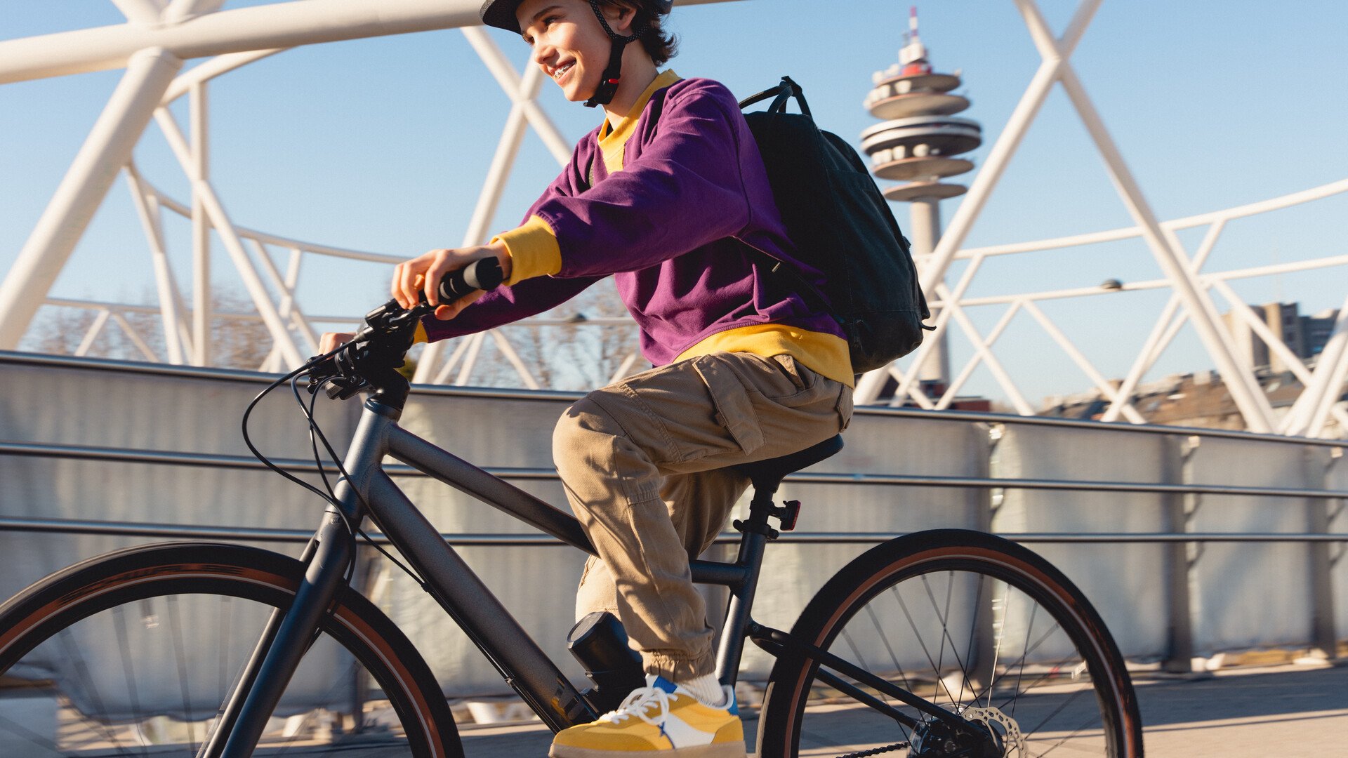 Ein Junge mit lila Pullover fährt auf dem woom EXPLORE e.