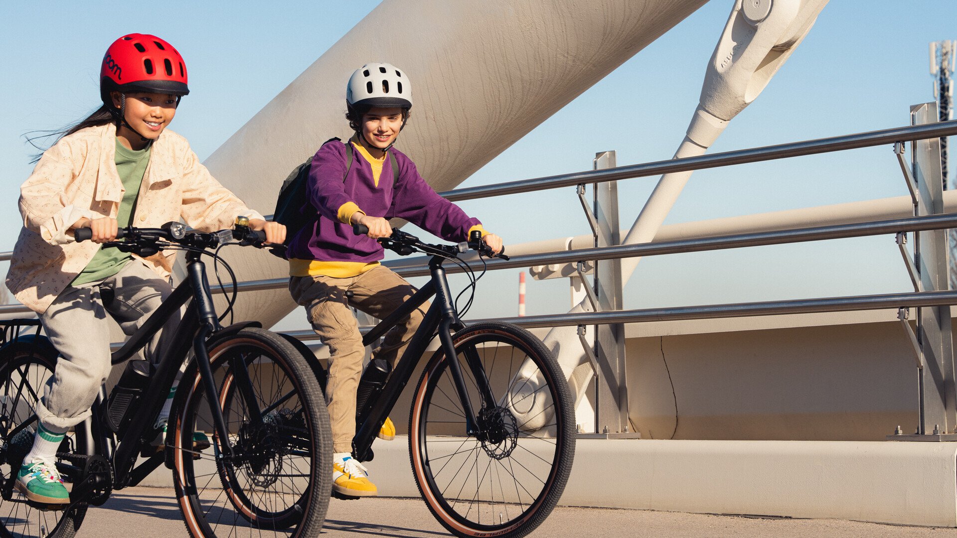 Zwei Kinder fahren auf dem woom EXPLORE e E-Bike nebeneinander.