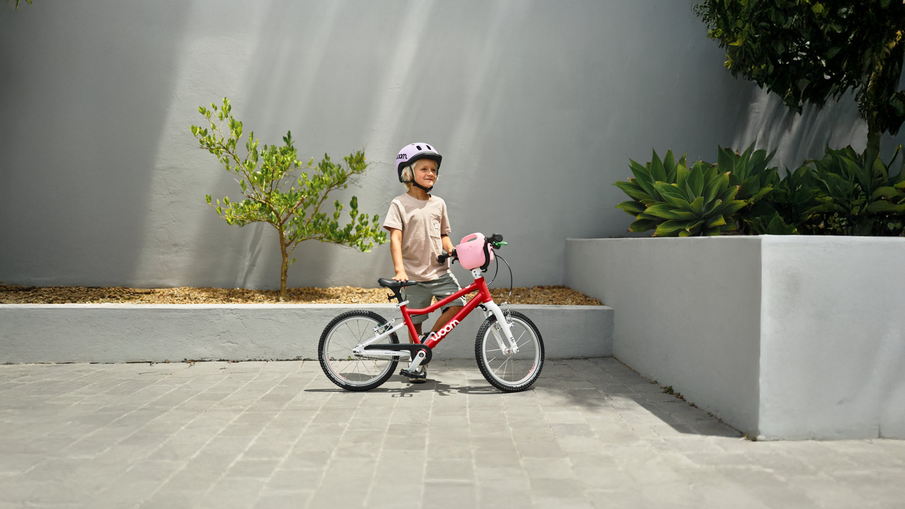 Animation die abwechselnd Kinder verschiedenen Alters mit woom READY Kinderhelmen und woom GO bikes in verschiedenen Größen und Farben von Größe 1 bis Größe 4 zeigt.