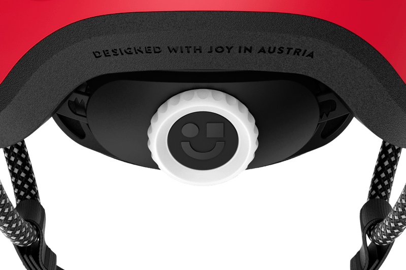 Zoom sur la molette de réglage blanche avec sticker souriant et réfléchissant pour le réglage du casque enfant READY de woom
