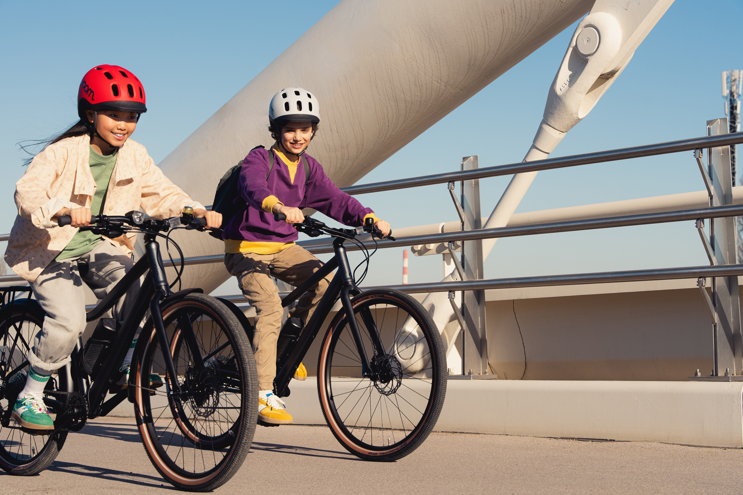 Ein Mädchen und ein Junge fahren nebeneinander auf woom EXPLORE e E-Bikes.