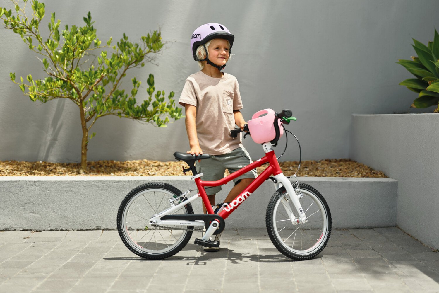Animatie toont afwisselend kinderen van verschillende leeftijden met woom READY kinderhelmen en woom GO fietsen in verschillende maten en kleuren van maat 1 tot maat 4.