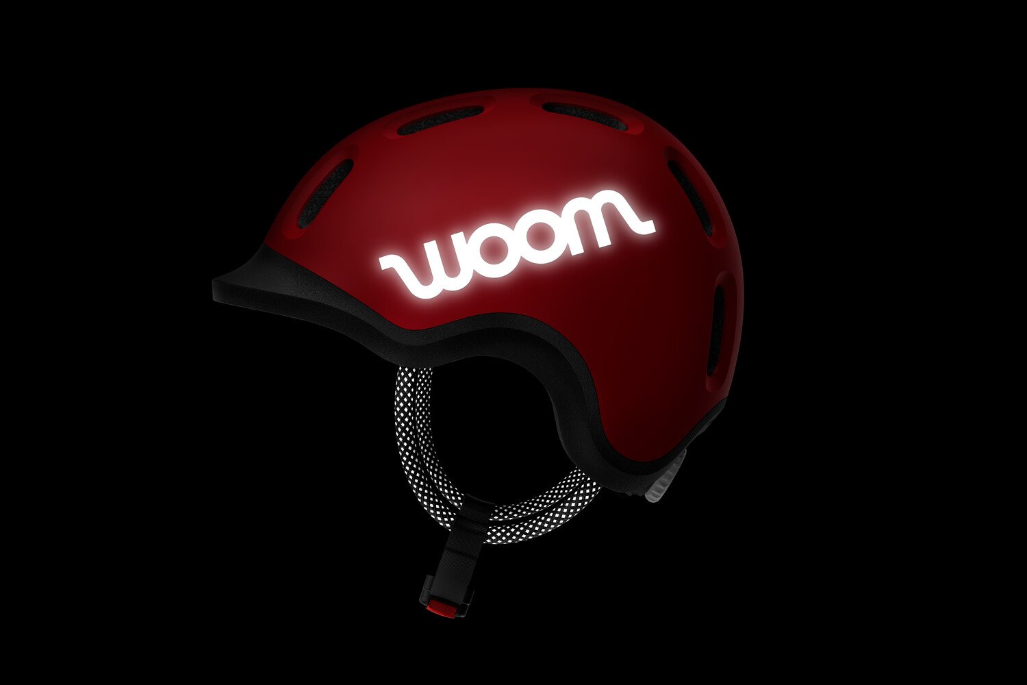 Side view of the READY Kids' Helmet with the reflective woom logos and straps in the dark