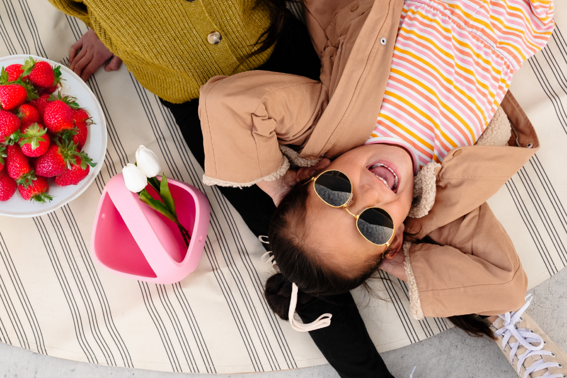 Une petite fille roule sur son nouveau woom 2, équipé du panier woom de nouvelle couleur rose. Elle y transporte sa peluche.