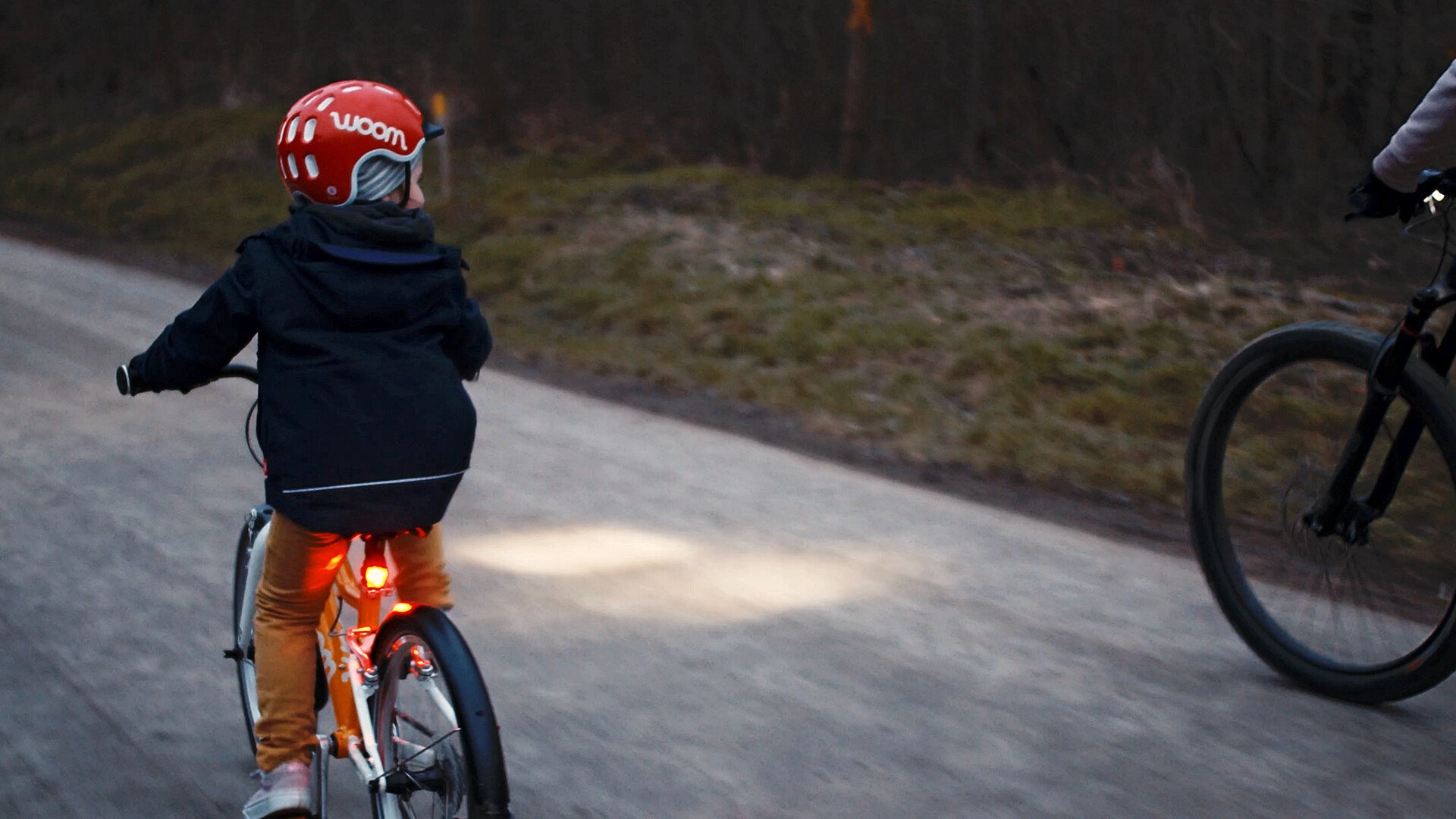 Kinder auf dem Fahrrad in einem Winterabend. Das Licht wird von