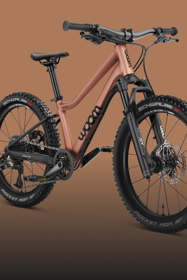 Seitliche Frontansicht des Kindermountainbikes woom OFF AIR mit Federgabel in der Farbe terra coppa.
