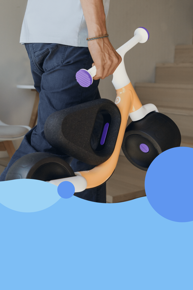 A man is making use of the easy-carry function to carry the woom WOW upstairs by its handlebars.