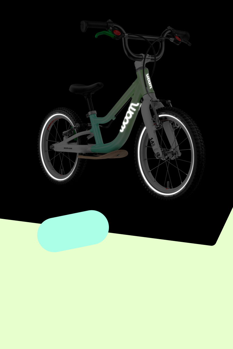 Side front view in the dark of the limited edition woom GO children's bike with reflective elements including woom logos