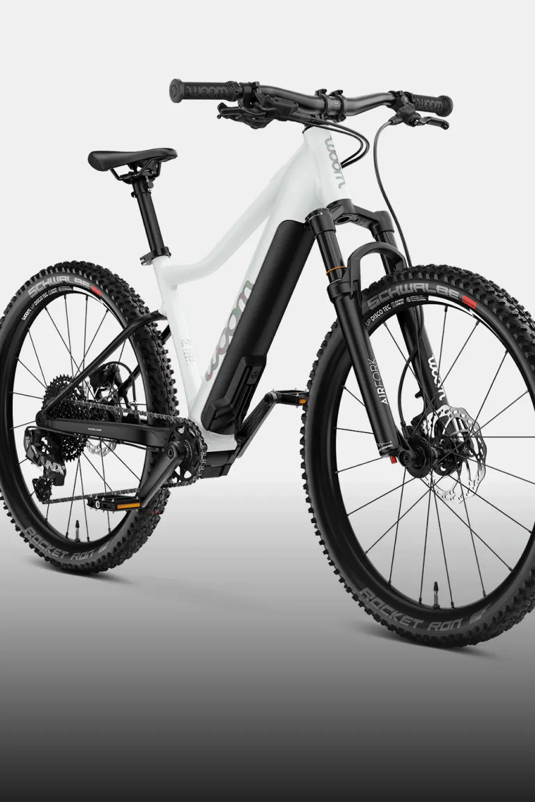 Angled view of the woom UP e-mountain bike in cirrus cloud against a black background.