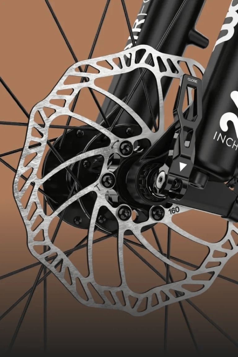 Detailed view of the powerful disc brakes on the front wheel of a woom OFF 5 kids' mountain bike