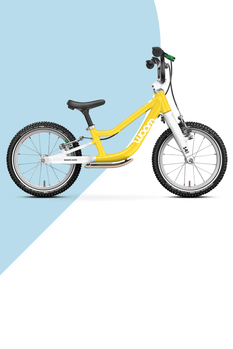  Yellow woom GO balance bike on a light blue and white background.