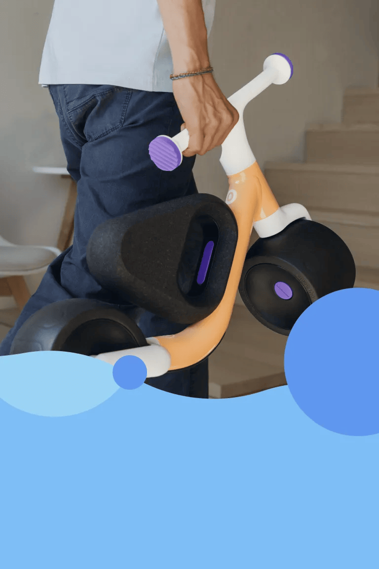 A man is making use of the easy-carry function to carry the woom WOW upstairs by its handlebars.