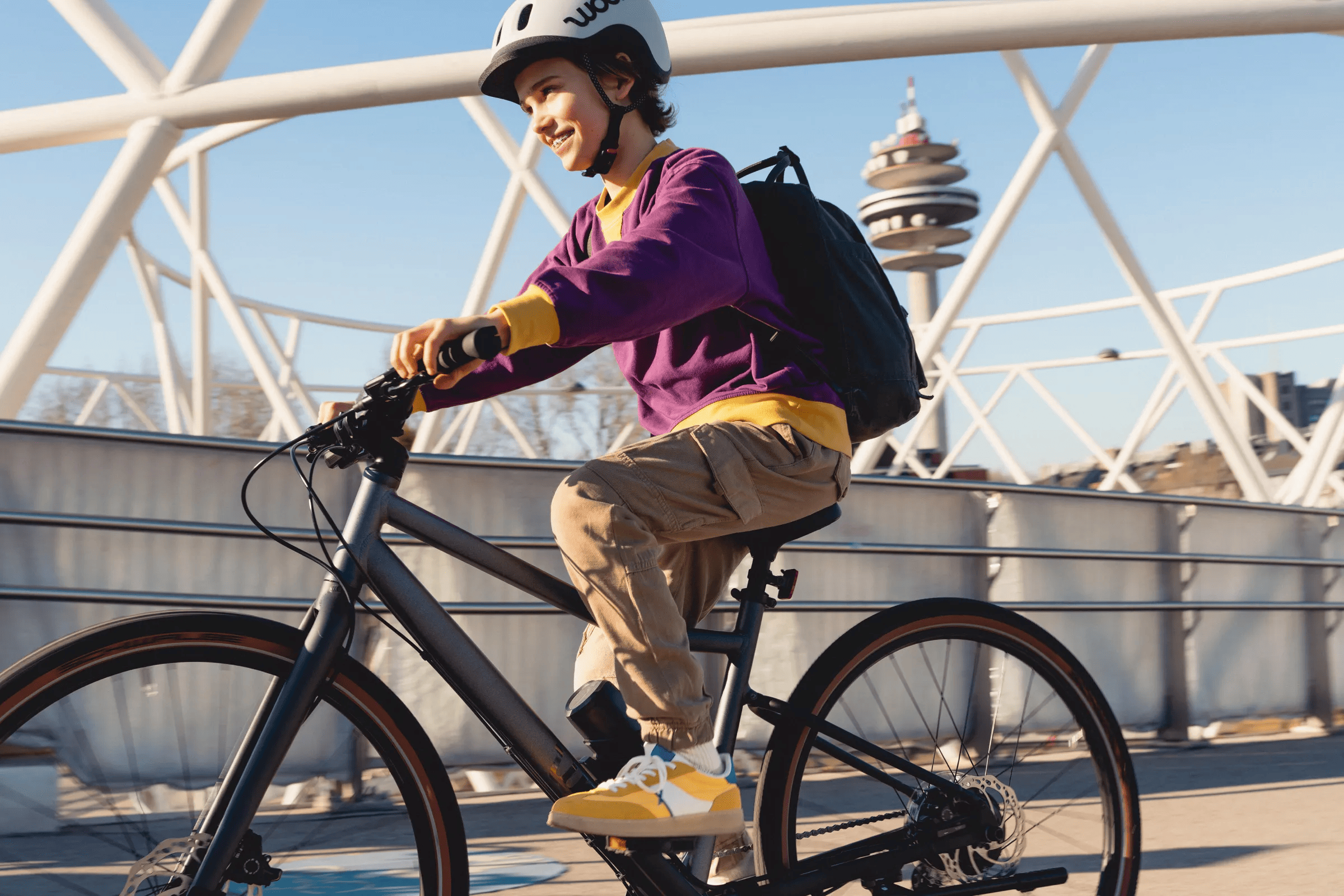 Un adolescent avec un pull violet roule sur son woom EXPLORE e.