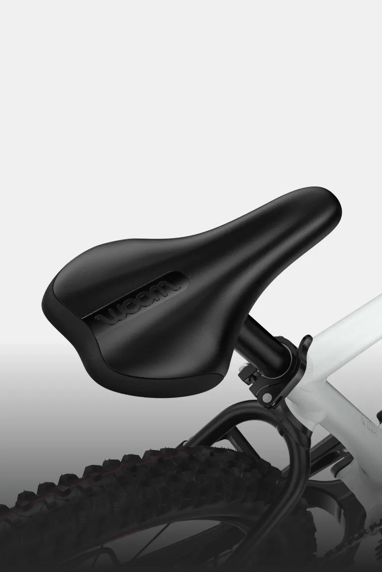 Close-up of the black saddle and white frame with shimmering woom logo in cirrus cloud.